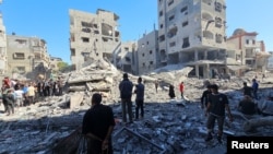 Palestinians gather at the site of Israeli air strikes on residential buildings in the Gaza Strip.
