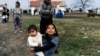 A Romany girl carries her brother on a street in the Bulgarian village of Ekzarh Antimovo.