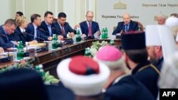 Acting Ukrainian President Oleksandr Turchynov (right) speaks, flanked by Prime Minister Arseniy Yatsenyuk (center), during the opening of roundtable talks on Ukraine's deepening crisis in Kyiv on May 14.