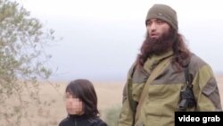 A child militant is shown killing two men identified as “Russian agents.” 