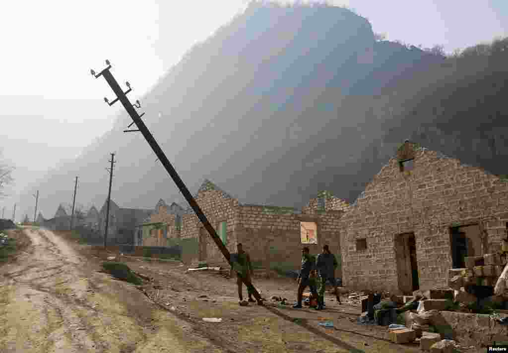 Ethnic Armenian soldiers topple a telephone pole in the village of Knaravan – a settlement recently built by ethnic Armenians in the Karvachar/Kalbacar district near Azerbaijan’s border with Armenia.