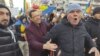 Un bărbat încearcă să liniștească un manifestant care huiduie o echipă de jurnaliști la protestul AUR, pe 12 ianuarie 2025.