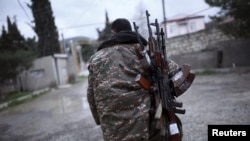 A soldier with separatist forces in Nagorno-Karabakh carries weapons in Martakert province, which was reportedly affected by recent clashes over the breakaway Caucasus region. 