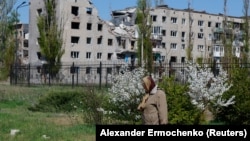 A woman walks in front of an apartment building damaged in the course of Russia-Ukraine war. (file photo)
