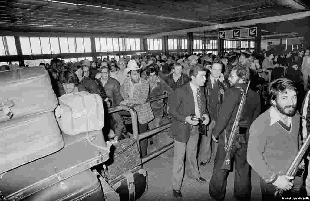 Armed men loyal to Ayatollah Khomeini stand guard at Teheran's Mehrabad International Airport on February 18, 1979. Hundreds of U.S. citizens attempted to board an evacuation flight to leave Iran.