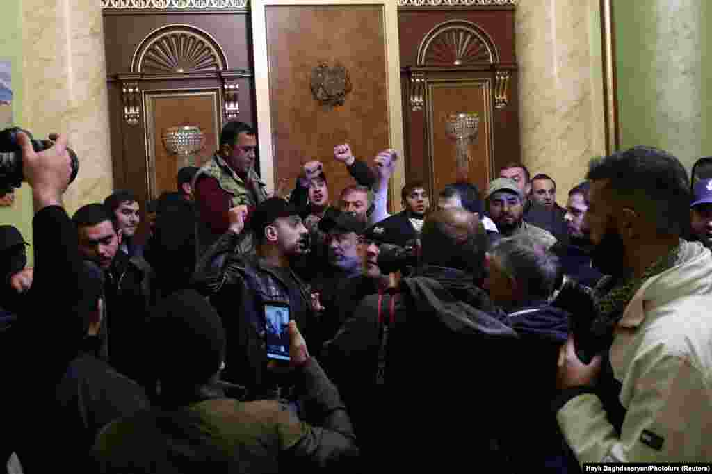 People stand angrily at the entrance to government headquarters in Yerevan. Armenia's Defense Ministry released a statement about the conflict in Nagorno-Karabakh saying "it is time to stop the bloodshed." 