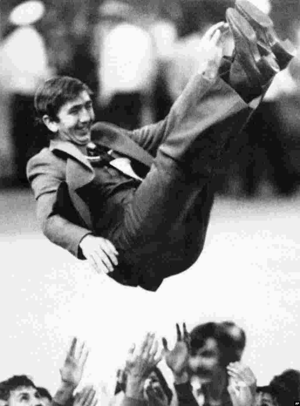 An unidentified Soviet volleyball coach is tossed into the air after his team beat Bulgaria to win gold. 