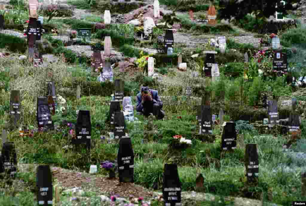 A man mourns his wife in one of Sarajevo&#39;s ever-expanding cemeteries in 1993.&nbsp;