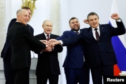 Russian President Vladimir Putin (third left) and the Russian-installed leaders in Ukraine's Donetsk, Luhansk, Kherson, and Zaporizhzhia regions celebrate at the signing ceremony on September 30.
