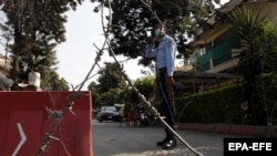 A Pakistani security official stands guard outside a residential area of Islamabad sealed off as part of the new smart lockdown after increasing numbers of coronavirus infections were reported.