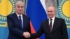Kazakh President Qasym-Zhomart Toqaev (left) and Russian President Vladimir Putin shake hands during a joint news conference following their talks at the Kremlin in Moscow on February 10, 2022, two weeks before Moscow's full-scale invasion of Ukraine.