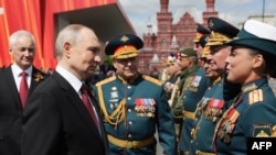 Na fotografiji koju je distribuirala ruska državna agencija Sputnjik, ruski predsjednik Vladimir Putin pozdravlja vojne komandante nakon vojne parade povodom Dana pobjede na Crvenom trgu u Moskvi 9. maja
