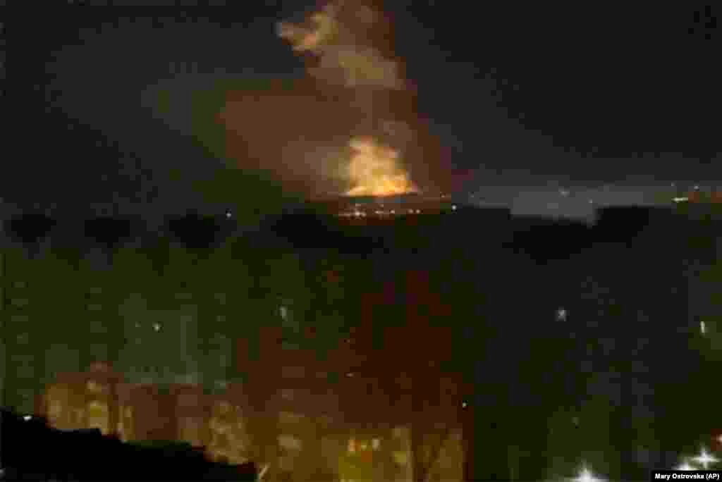 Flames are seen from an area near the Dnieper River in Kyiv.