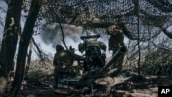Ukrainian soldiers fire a cannon near Bakhmut in the Donetsk region. 