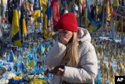Жінка плаче біля народного меморіалу пам'яті убитих Росією. Київ