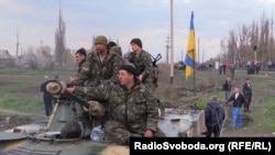 At a railway crossing near Kramatorsk, local residents block a convoy of Ukrainian military equipment.