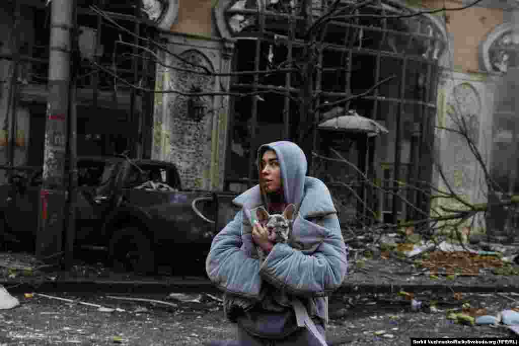 Жанчына трымае свайго сабаку пасьля расейскага ўдару па Кіеве, 20 сьнежня 2024 
