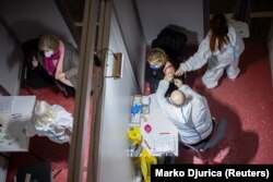 A woman receives a dose of the Sinopharm vaccine as Serbia begins mass vaccination against COVID-19 in Belgrade on February 2.