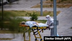 Коронавируска чалдыккан бейтапты сүйрөп бараткан медкызматкер. Москва, 30-июнь, 2021-жыл.