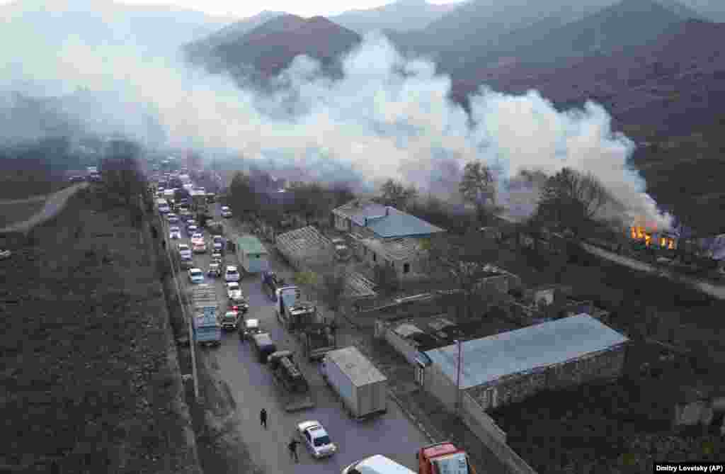 Smoke from a burning house drifts over a traffic jam as ethnic Armenians flee Karvachar/Kalbacar – which is internationally recognized as part of Azerbaijan. Ethnic Armenians point to ancient Christian monuments in the area that mark their historic ties to the land.