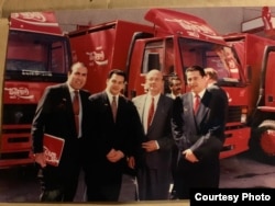 Mansur (2nd left) and Farid (right) Maqsudi pose for a photo at the Coca-Cola plant in Tashkent. (undated)