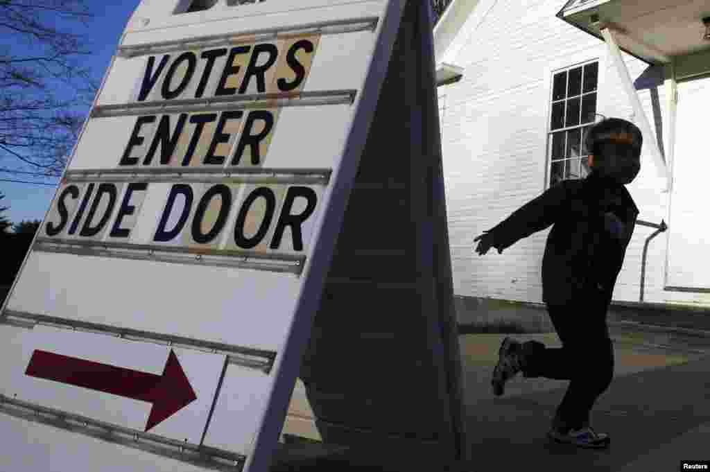 A boy runs to tell voters where to enter the Town Hall of Canterbury, New Hampshire.