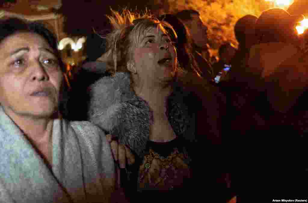 Protesters react to the news outside the Armenian parliament building in Yerevan.
