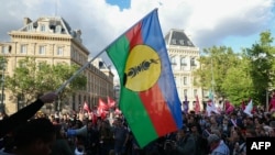 A protester holds the flag of New Caledonian nationalists at a demonstration in Paris on May 16.