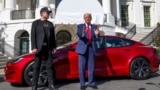 Президент США Дональд Трамп (справа) вместе с Илоном Маском на фоне автомобиля Tesla, архивное фото