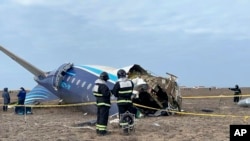 Рятувальники працюють над уламками Embraer 190 ї, що лежить на землі біля аеропорту Актау, Казахстан. Це фото оприлюднене прес-служби МНС Казахстану,