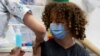 Un adolescent primește o doză de vaccin împotriva coronavirusului la Tel Aviv. Varianta Delta se transmite în special la tineri și adolescenți și prin intermediul lor.