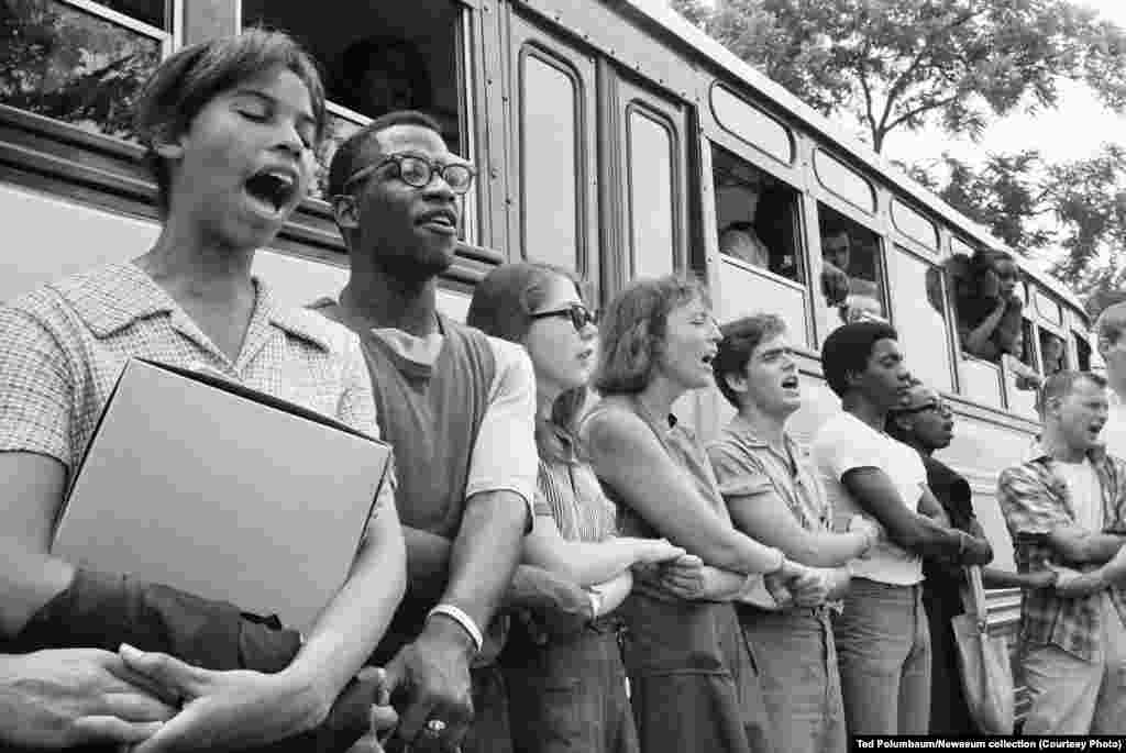 Student activists join hands and sing as they prepare to leave Ohio to register black voters in Mississippi in 1964. The voter registration campaign was known as Freedom Summer.