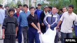 Residents carry bodies away from central Andijon after government troops opened fire on demonstrators on May 13, 2005.