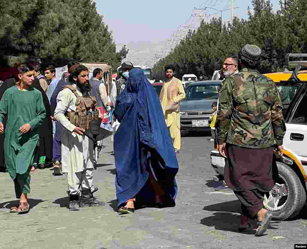 A woman covered by a burqa on the street in Kabul on August 27. A female Kabul resident who spoke to RFE/RL by encrypted messaging said there was uncertainty in the Afghan capital about what Taliban rule will be like. "The spokesperson of the Taliban says they have changed and blah blah blah," the woman wrote. "But ordinary Taliban on the streets are so much different and rude, carrying guns." 
