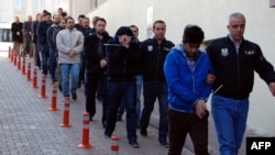 Turkish police officers escort people under arrest for alleged links with U.S.-based Muslim cleric Fethullah Gulen, whose movement Turkey considers a terrorist organization in 2017. (file photo)