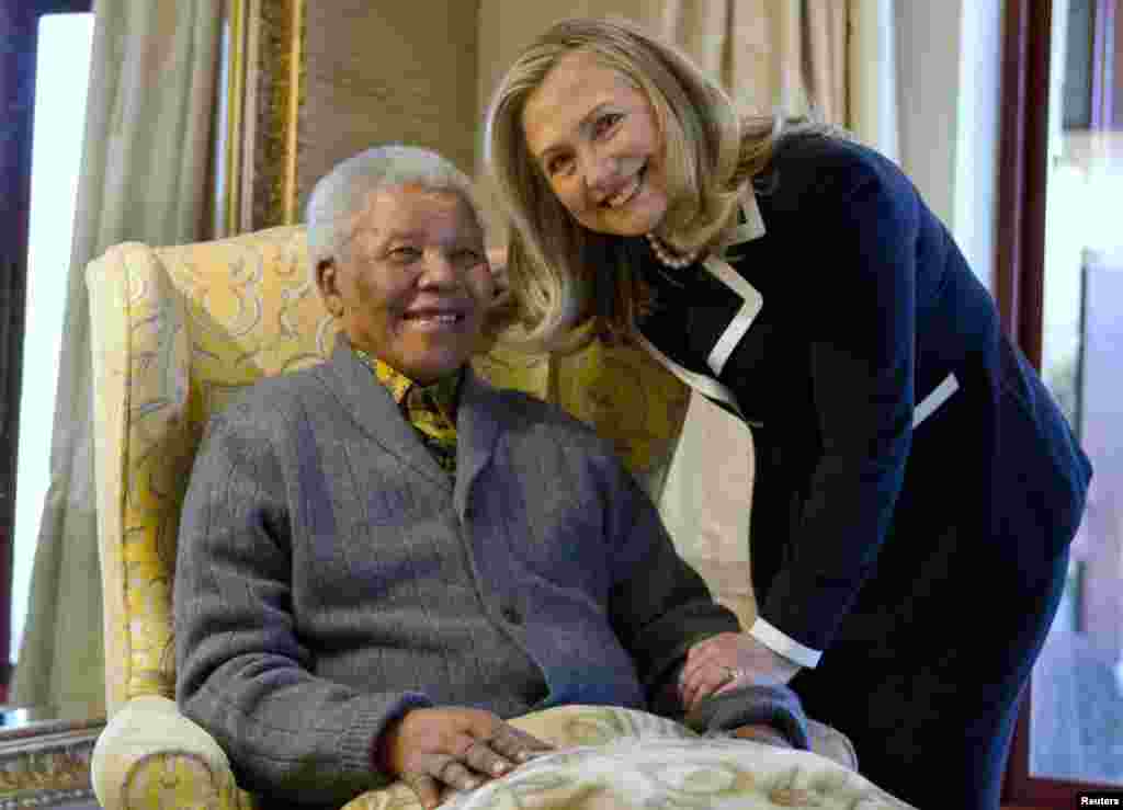 U.S. Secretary of State Hillary Clinton poses for a photograph with Mandela at his home in Qunu in August 2012.