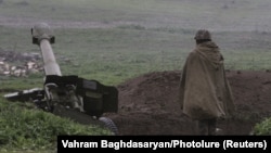 An ethnic Armenian soldier in Nagorno-Karabakh's forces stands near an artillery unit in the town of Martakert, where clashes with Azeri forces are taking place, on April 3.